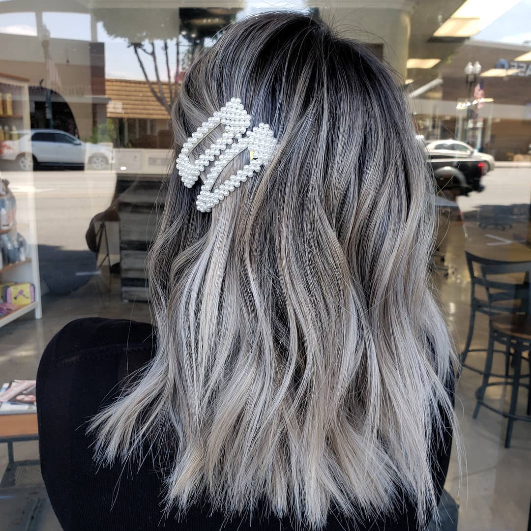 Colorazione tridimensionale e maxi fermagli con perle, per un look glam e chic