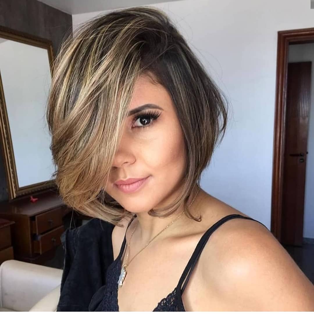 Bob corto con ciuffo voluminoso e lungo sul davanti e balayage biondo