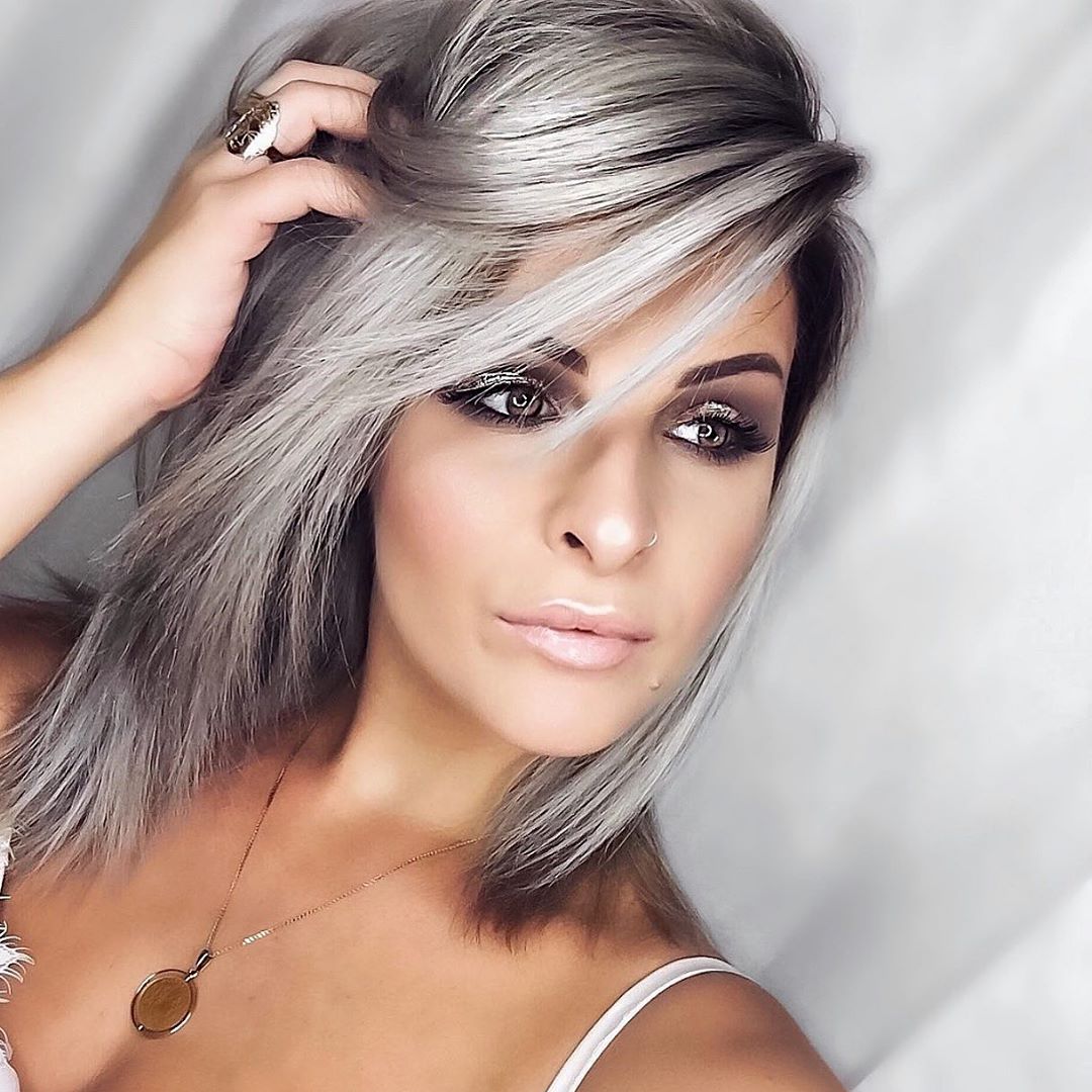Capelli medi con ciuffo voluminoso e balayage biondo platino su base scura