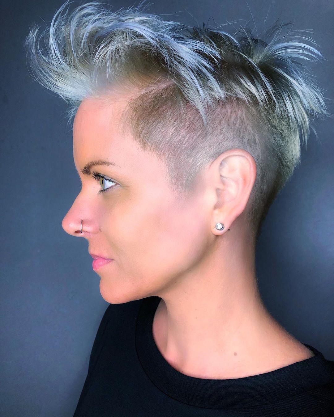 Pixie asimmetrico rasato con ciuffo, color biondo con sfumature azzurre