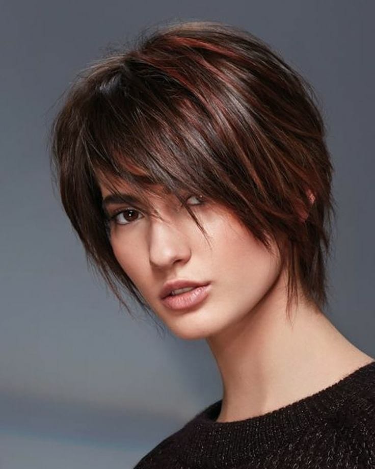 Pixie cut che incornicia del tutto il volto con frangia, quasi un caschetto cortissimo, arricchito da balayage luminoso
