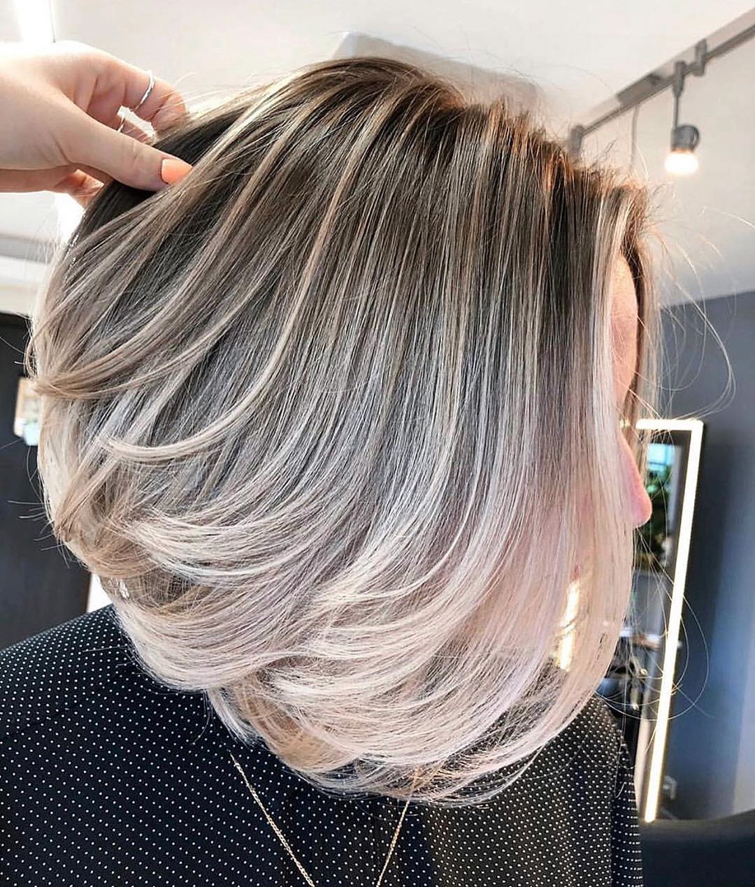 Capelli corti con scalature intense e balayage biondo, un taglio movimentato e ultra luminoso