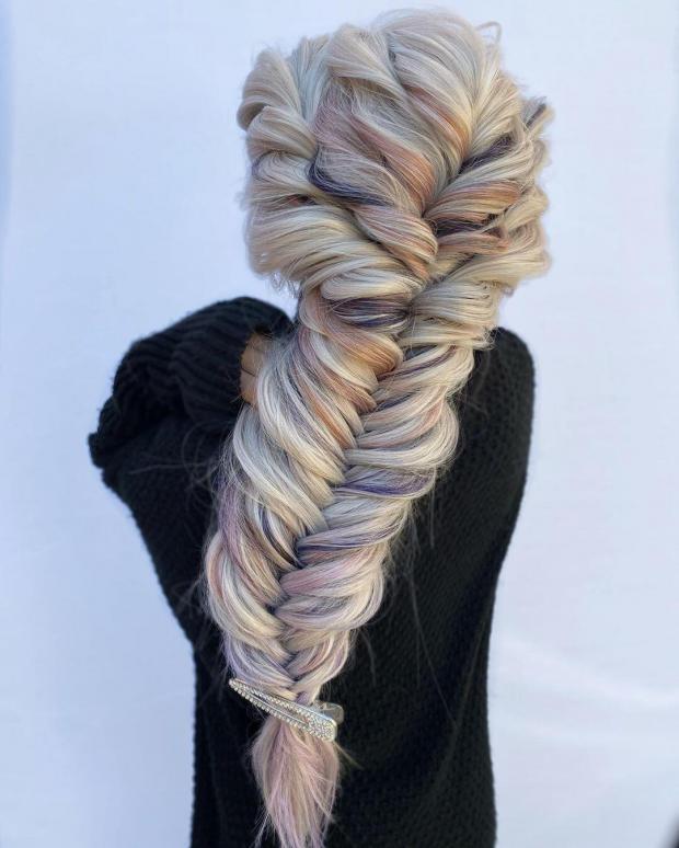 treccia a spina di pesce su capelli biondi con ciuffi rosa e viola