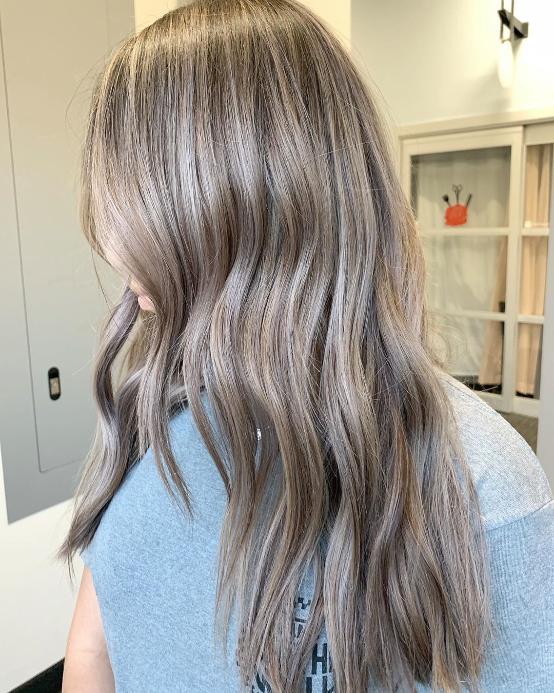 Capelli lunghi, scalati e mossi biondo cenere con balayage