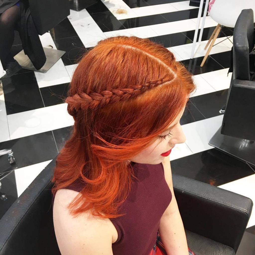 Capelli arancioni con taglio medio e balayage, acconciati con delicate trecce