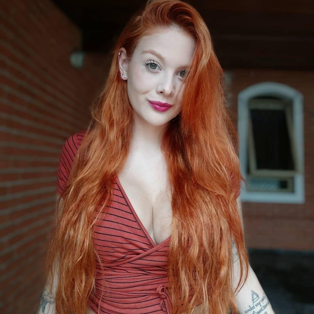 Lunghi capelli arancioni con styling modo e ciuffo asimmetrico