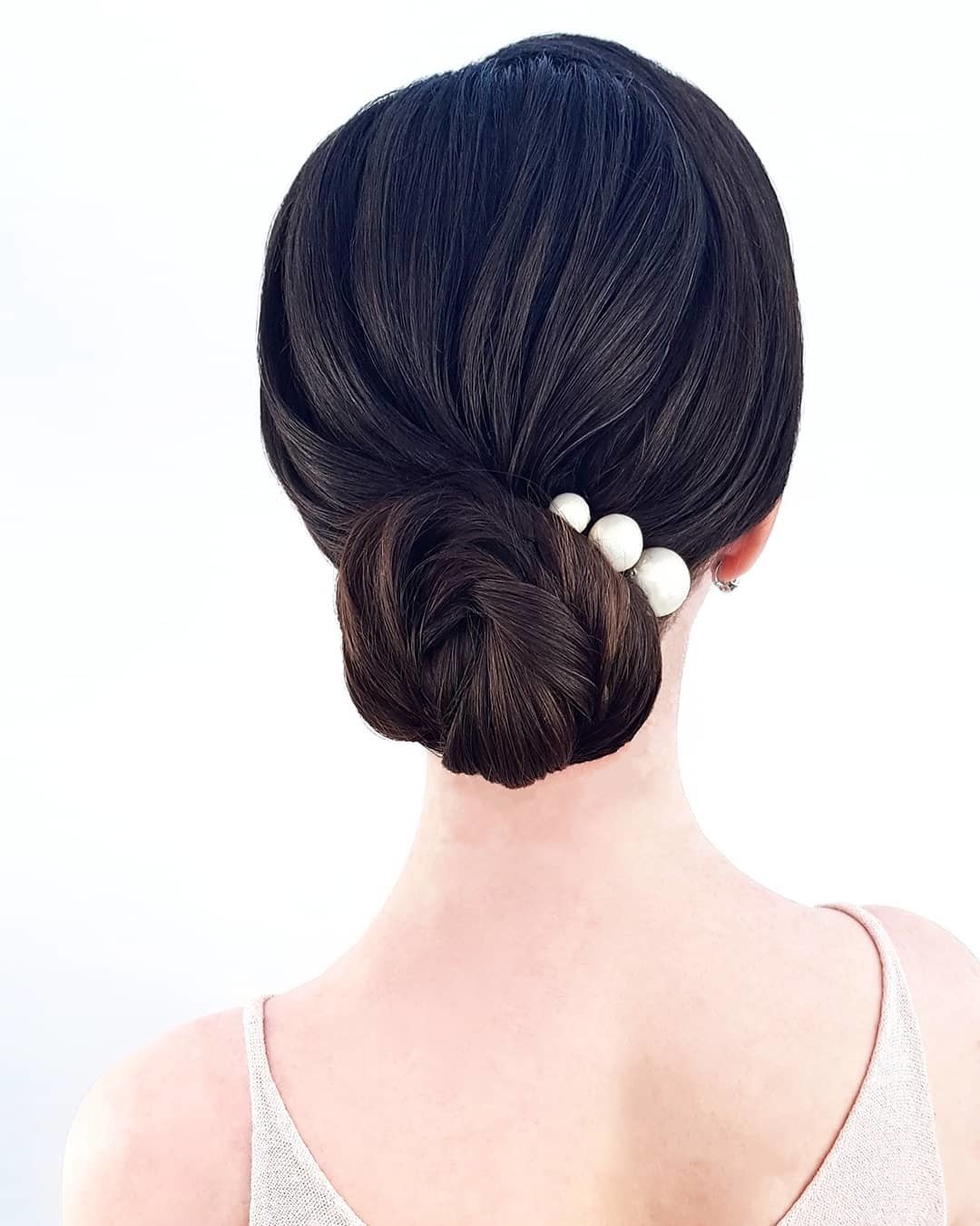 Chignon basso e rigoroso con perle
