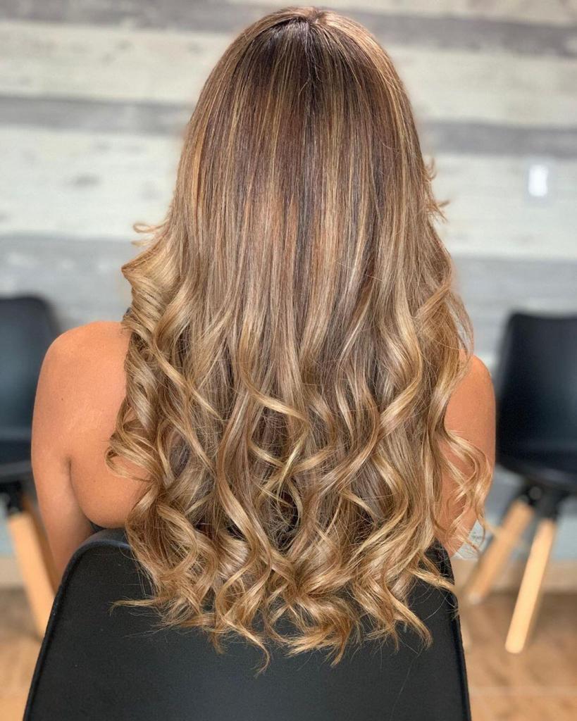 Capelli lunghi e ondulati vicino alle punte arricchiti da un goloso balayage caramello