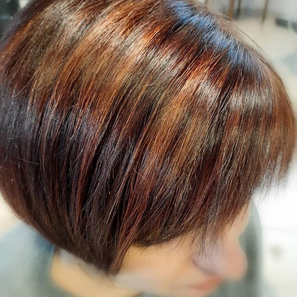 Bob corto e scalato con frangia e balayage castano