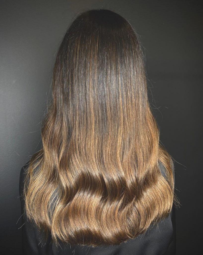 Capelli lunghissimi e lisci, leggermente ondulati sulle punte, con balayage nocciola